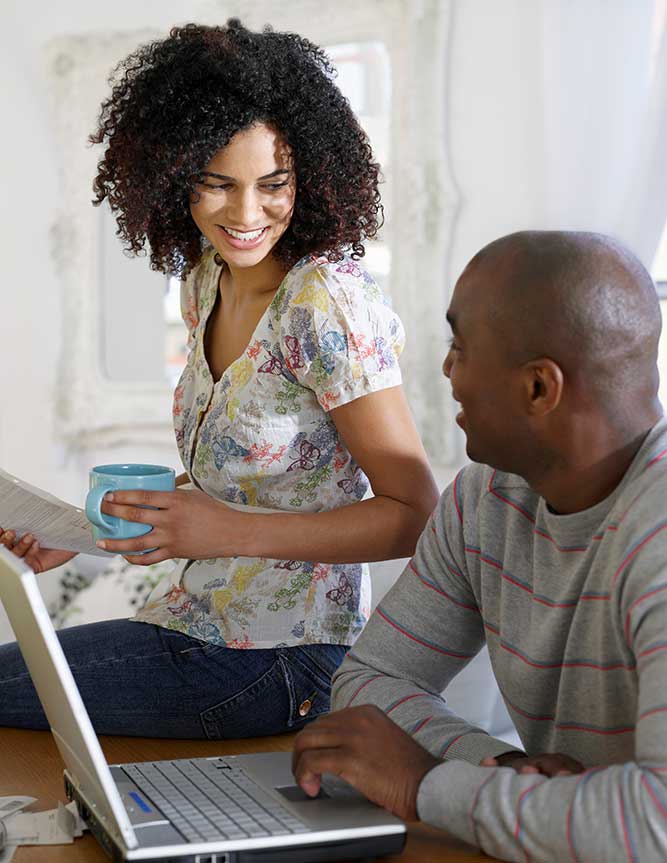 couple-going-over-finances African American couple sitting at table with laptop and bills