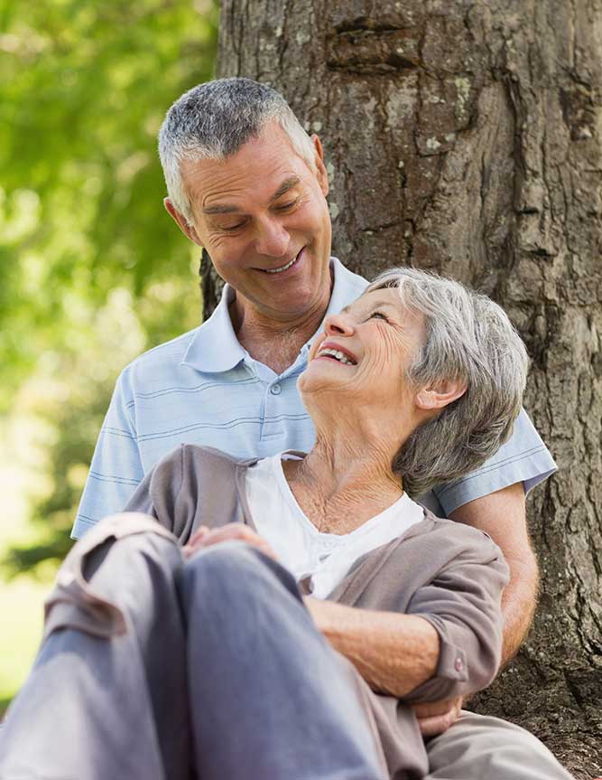Happy relaxed senior couple sitting at park
